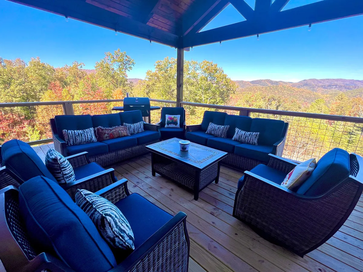 A tranquil wooden deck with plush seating and a grill, set against a stunning mountain view. The arrangement is ideal for outdoor meals, celebrations, or simply savoring nature’s beauty with friends and family.