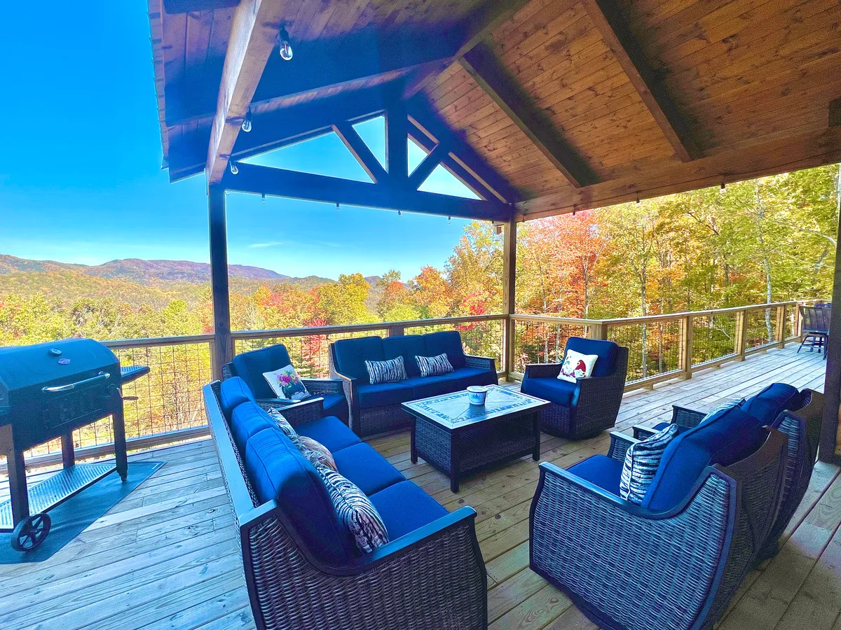 This image shows a comfortable outdoor seating area with a grill and a panoramic mountain view. It's designed for outdoor dining, group gatherings, and soaking in a stunning sunset or night sky with friends and family.